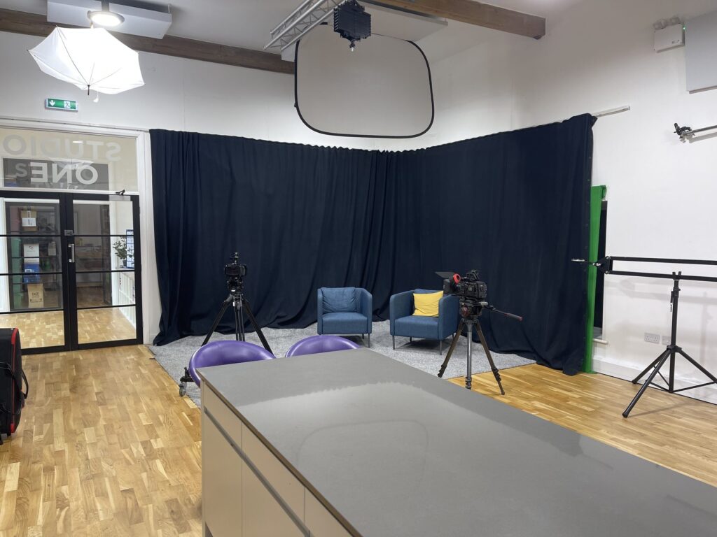 Blackout curtain set in Studio One with two chairs and cameras positioned for an interview