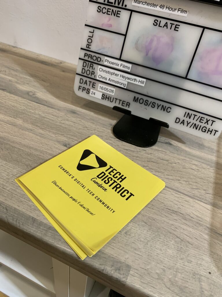 Tech District Cumbria notebook beside a clapperboard at the studio launch